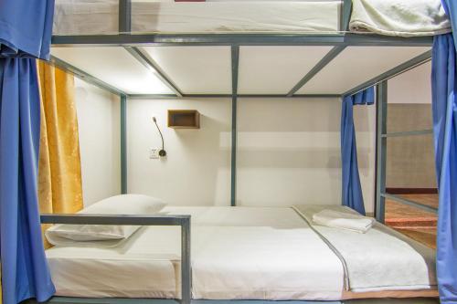 two bunk beds in a room with blue curtains at Bokre Angkor Hostel in Siem Reap