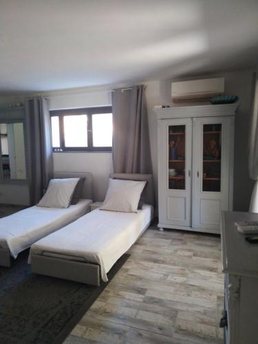 - une chambre avec 2 lits et une armoire avec des fenêtres dans l'établissement Sous le mûrier, à Six-Fours-les-Plages