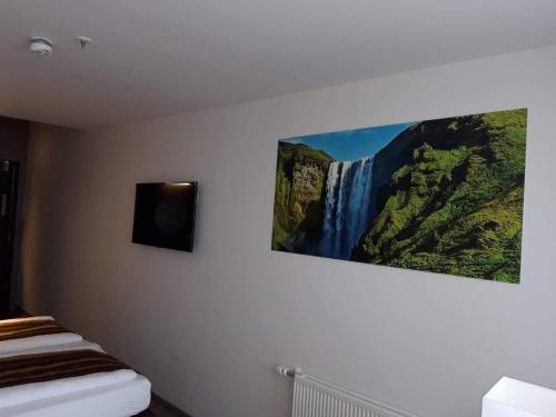 a painting of a waterfall hanging on a wall at Hotel Duus by Keflavik Airport in Keflavík