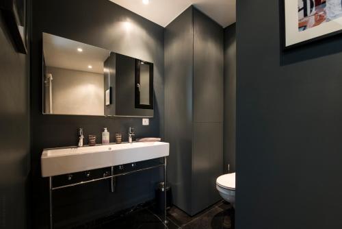 a bathroom with a white sink and a toilet at Smartflats Premium - Palace du Grand Sablon in Brussels