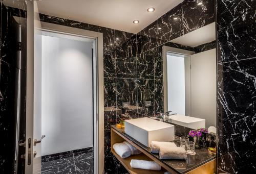 a bathroom with two sinks and a mirror at Kedem Hotel - Adults Only in Tirat Karmel