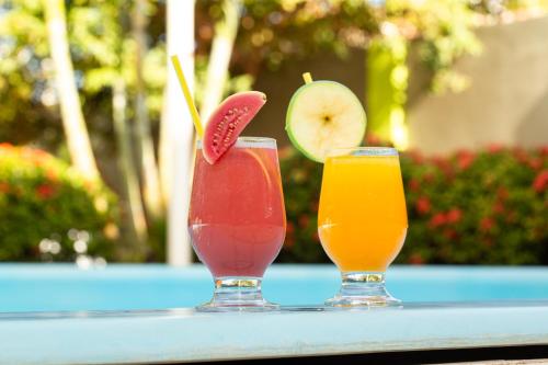 two cocktails sitting on a table with a drink at Pousada o Caribe de Maragogi in Maragogi