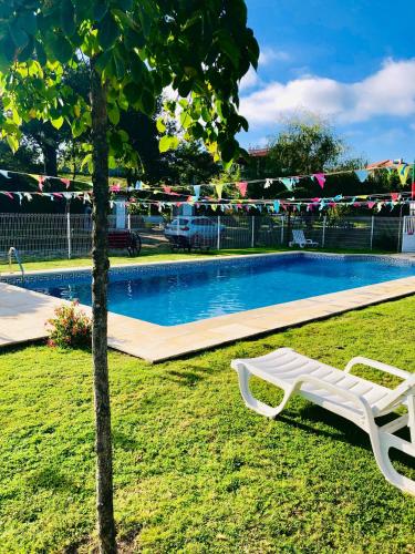 a white chair sitting next to a swimming pool at Casa da Quinta da Prelada Simão partie basse in Celorico de Basto
