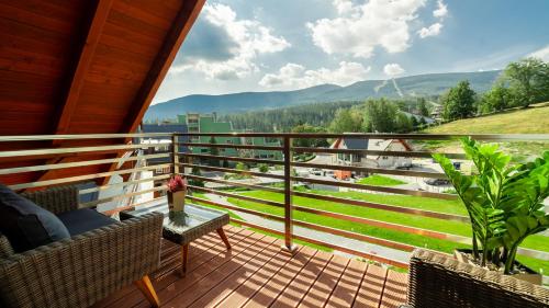 a balcony with chairs and a view of the mountains at Triventi Mountain Residence, Sun & Snow in Karpacz
