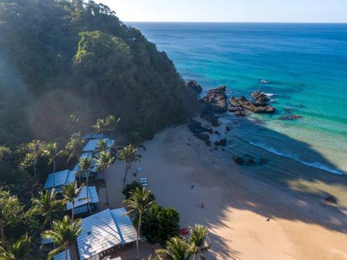 - une vue aérienne sur une plage bordée de palmiers et l'océan dans l'établissement Duli Beach Resort, à El Nido