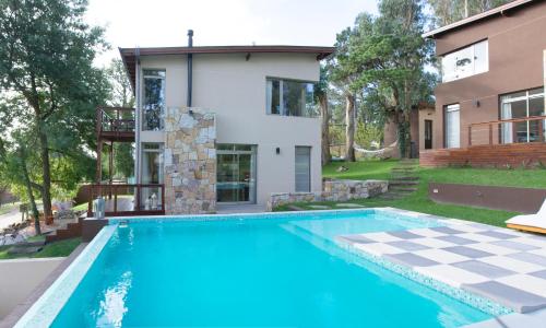 una casa con piscina frente a una casa en Cabañas Chic Boutique en Sierra de los Padres