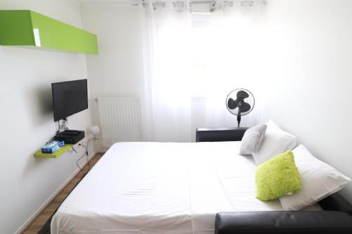 1 dormitorio con 1 cama blanca y TV en Studio scandinaves - Disneyland Paris, en Serris