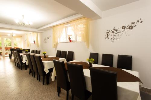 a dining room with long tables and chairs at Pensiunea Casa Alexandra in Vatra Dornei