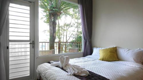 a bedroom with a bed and a large window at SunSweet House in Fanlu