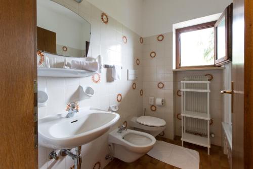 a white bathroom with a sink and a toilet at Pension Sankt Urban in Merano