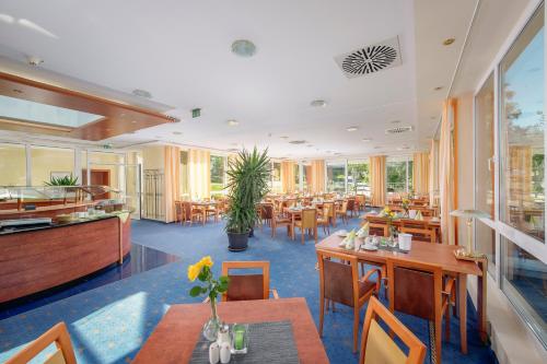 a restaurant with tables and chairs and a cafeteria at Das Allgäu in Maierhöfen