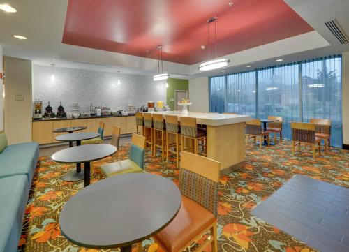 a cafeteria with tables and chairs and a counter at La Quinta by Wyndham Starkville at MSU in Starkville