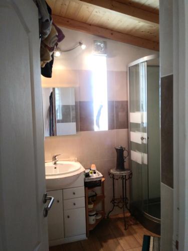 a bathroom with a sink and a mirror and a shower at Casinha do Sul in Faro