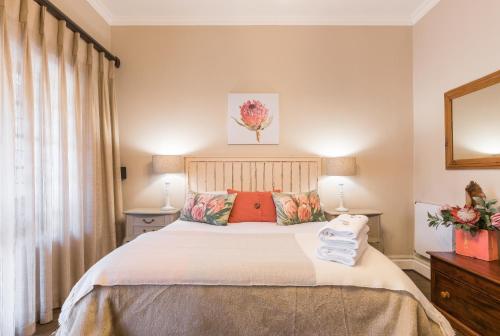 a bedroom with a bed with white sheets and red pillows at Caledon 23 Country House in George