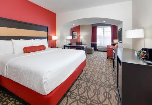 a hotel room with a large bed and a desk at La Quinta by Wyndham Starkville at MSU in Starkville