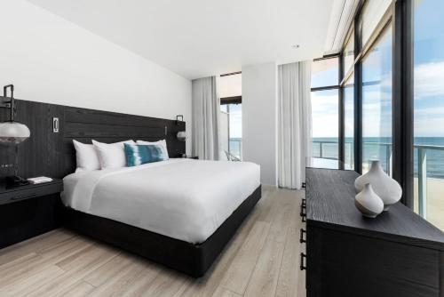 a bedroom with a large bed and a large window at Wave Resort in Long Branch