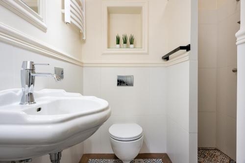 a white bathroom with a sink and a toilet at P&J Holiday Houses in Krakow