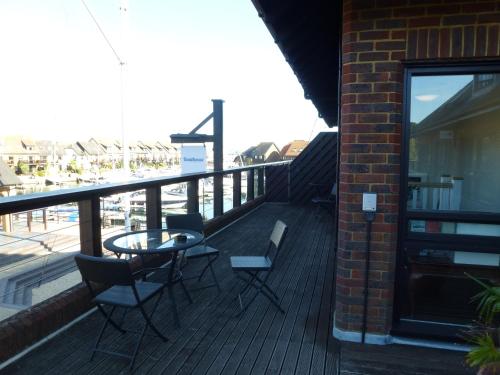 a balcony with a table and chairs on a building at Boathouse Hotel in Hythe