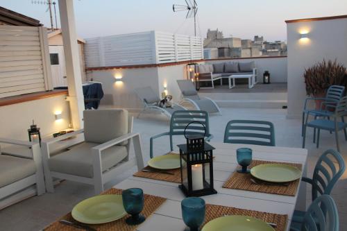 a patio with chairs and tables on a roof at Lanterna sul mare in Favignana