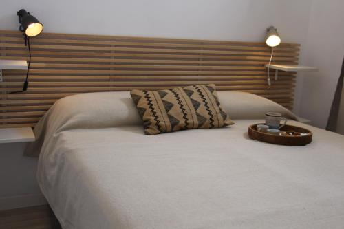a bed with a wooden headboard and a tray on it at Lanterna sul mare in Favignana