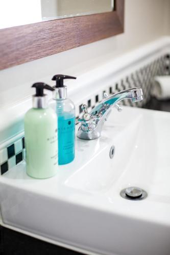 two bottles ofodorizers sitting on a bathroom sink at Premier Resort Mpongo Private Game Reserve in Macleantown
