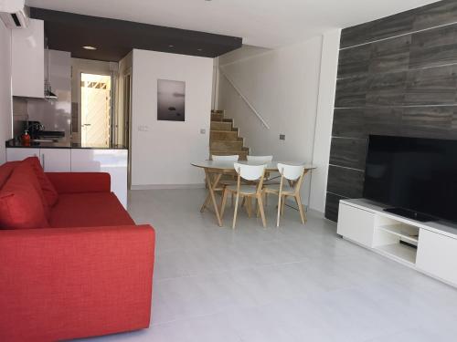 uma sala de estar com um sofá vermelho e uma mesa em Villa La Zenia 25 em Playa Flamenca