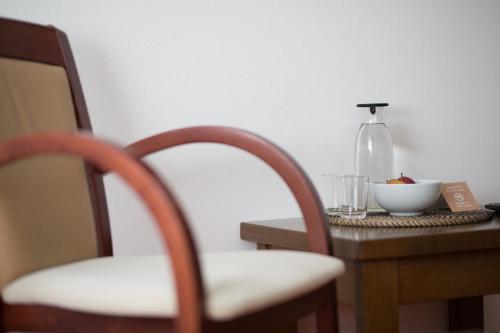 a table with a chair and a bottle on a table at Pension Sankt Urban in Merano
