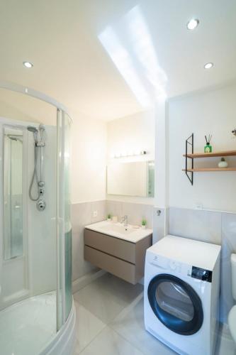 une salle de bain avec une machine à laver et un lavabo dans l'établissement Vue mer exceptionnelle entre Nice et Monaco, à Villefranche-sur-Mer
