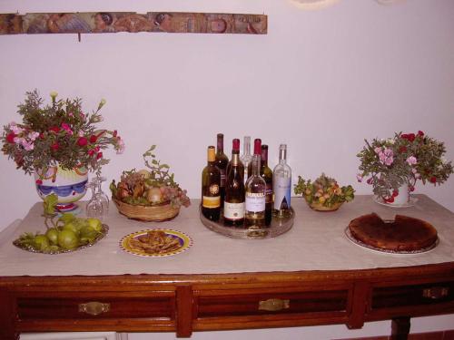 a table with bottles of wine and bowls of fruit at Turismo Rurale Baglio Fastuchera in Alcamo