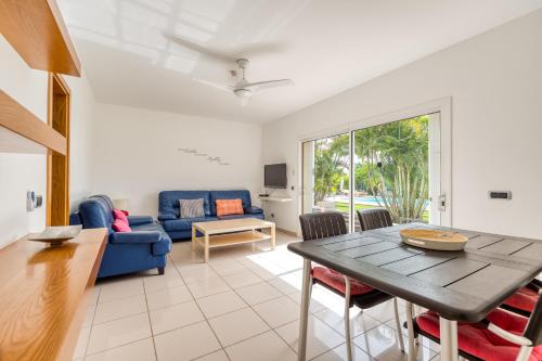 a living room with a blue couch and a table at Bungalows Cordial Macaro Beach in Playa del Ingles