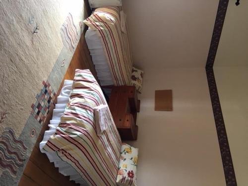a small bedroom with a bed with a striped blanket at Holmhurst Guest House in Bathurst