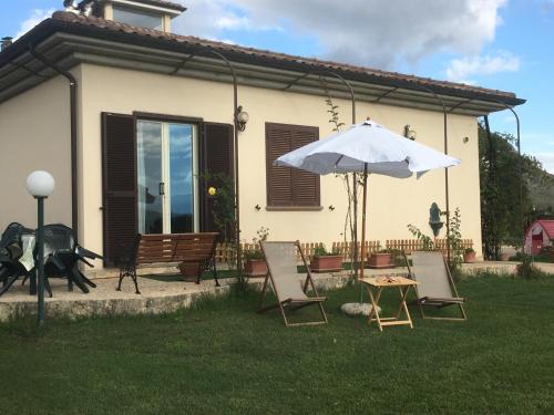 a patio with a table and an umbrella and chairs at Villa Giulia in Avezzano