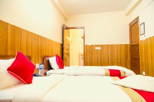 a hotel room with two beds with red pillows at Hotel The Doors in Kathmandu