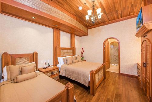 a bedroom with two beds and a chandelier at The Springs Resort & Spa at Arenal in Fortuna
