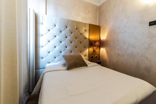 a bedroom with a large white bed with a headboard at Hotel Mythos in Milan