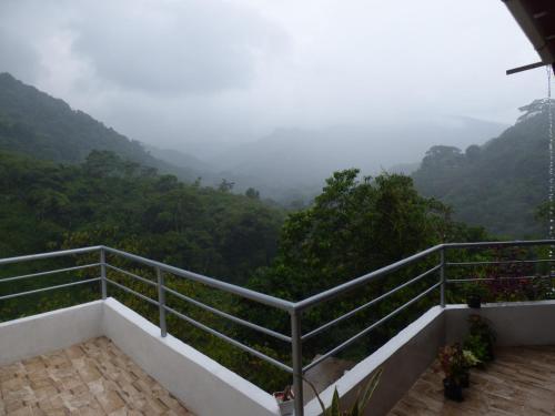 a balcony with a view of the mountains at Hostal Alto de la Montaña in Minca
