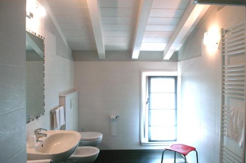a bathroom with two toilets and a sink and a window at Affittacamere Sale e Pepe in Cavaion Veronese