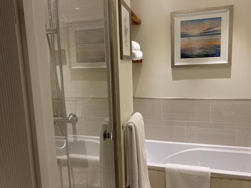劍橋的住宿－The Grapevine Studio，带淋浴和浴缸的浴室