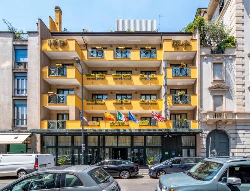 a yellow building with cars parked in front of it at Hotel Mythos in Milan