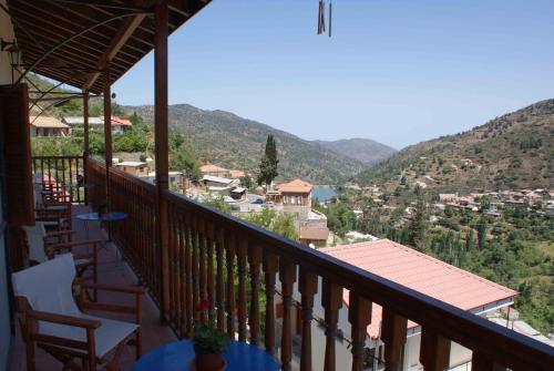 a balcony with chairs and a view of the mountains at ATRATSA Mountain Suites in Kalopanayiotis