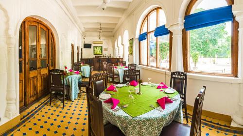 a dining room with a table and chairs in it at Neemrana's - Baradari Palace in Patiāla