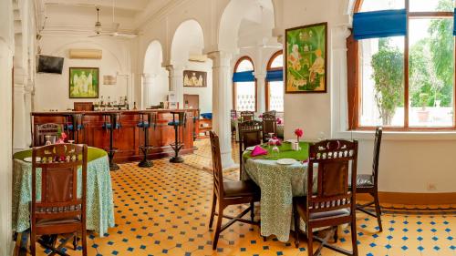 a restaurant with a table and chairs and a bar at Neemrana's - Baradari Palace in Patiāla