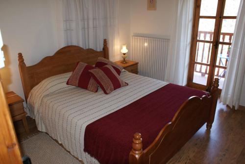a bedroom with a large bed with red pillows at ATRATSA Mountain Suites in Kalopanayiotis