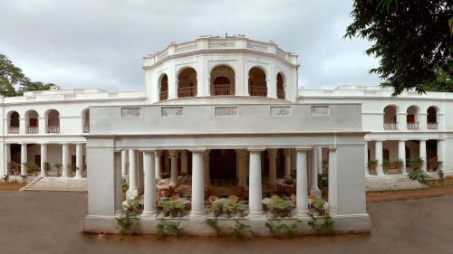 a white building with columns and a balcony at Neemrana's - Baradari Palace in Patiāla