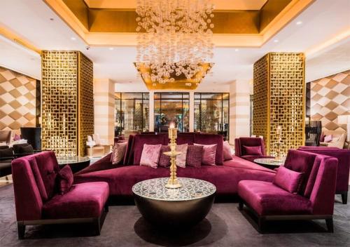 a living room with purple furniture and a chandelier at Sofitel Rabat Jardin Des Roses in Rabat