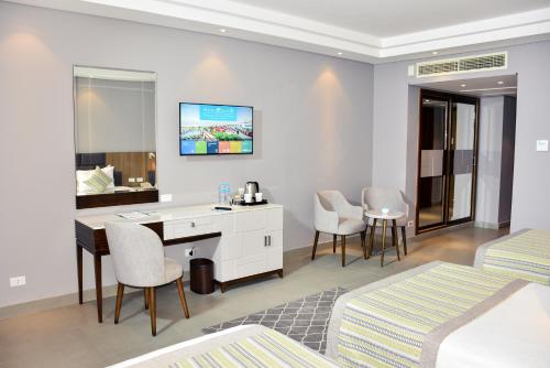 a hotel room with a desk and a bedroom at Sunrise Diamond Beach Resort -Grand Select in Sharm El Sheikh