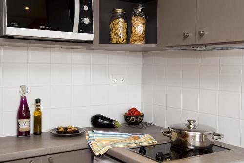 a kitchen with a stove with a pot and a plate of food at Aparthotel Adagio Paris XV in Paris