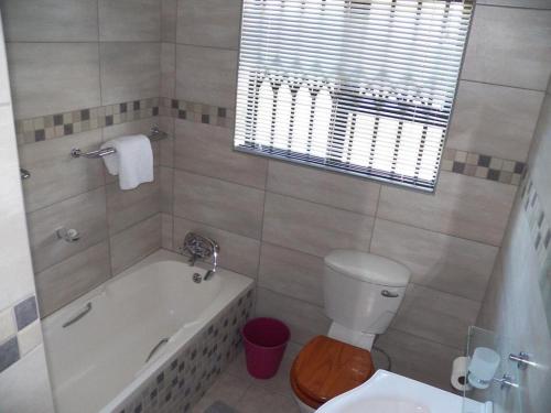 a bathroom with a tub and a toilet and a sink at 26 Pelser Plaat Meerensee in Richards Bay