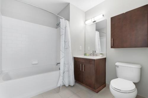 La salle de bains est pourvue de toilettes, d'une baignoire et d'un lavabo. dans l'établissement Global Luxury Suites Downtown Jersey City, à Jersey City