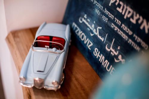 a toy car is sitting next to a book at Satori Hotel in Haifa